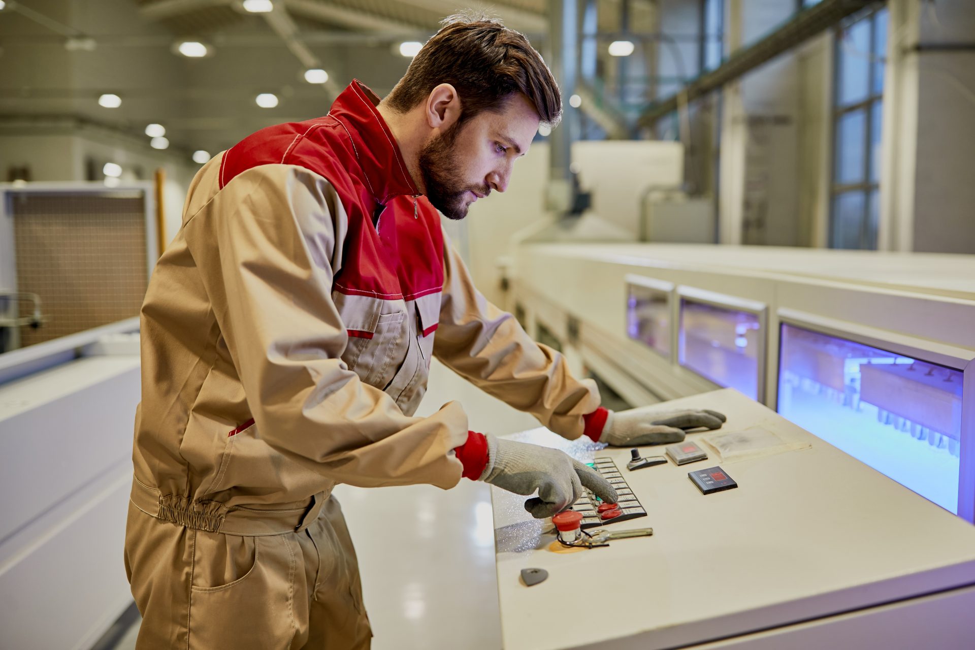 Opérateur expérimenté effectuant un geste technique automatisé sur un panneau de contrôle industriel